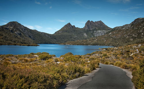 Scenic view of lake by mountains against sky