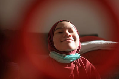 Close-up of young woman wearing hijab at home