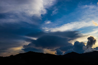 Low angle view of silhouette mountain against dramatic sky