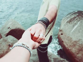 Midsection of woman holding hands in sea