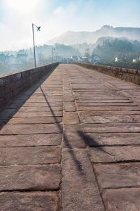 Road leading towards mountain against sky