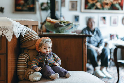 Toys on seat with person sitting in background at home