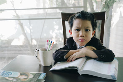 Portrait of boy sitting on table