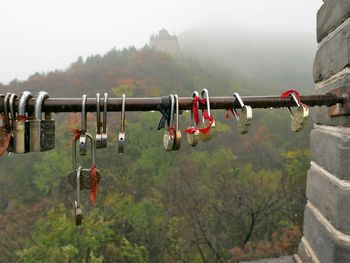 Close-up of padlocks hanging on railing against sky