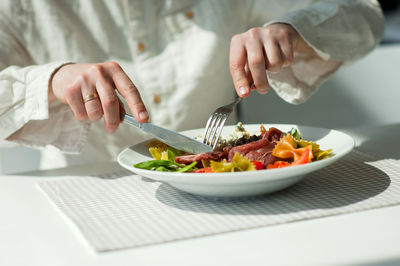 Midsection of man preparing food in plate