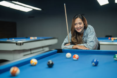 Young woman playing pool