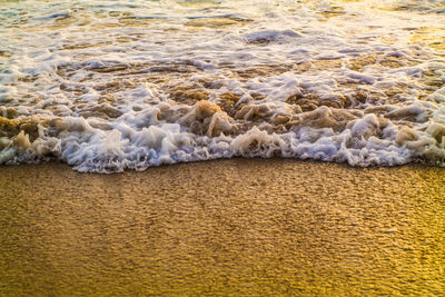 High angle view of waves rushing towards shore at dreamland beach, pecatu, bali, indonesia