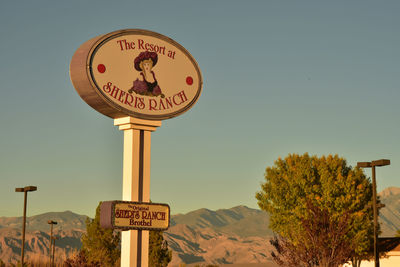 Low angle view of road sign against clear sky