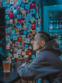 Portrait of man with drink sitting in kitchen