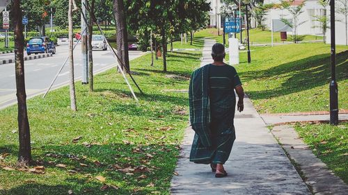 Rear view of a woman walking on grassland