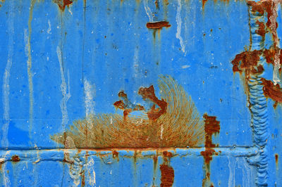 Piece of metal painted blue and marked by rust