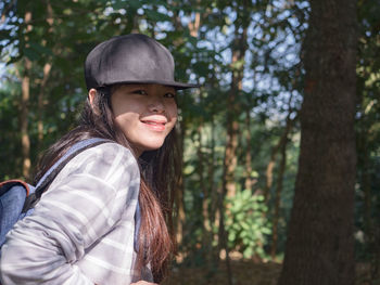 Portrait of young woman standing in forest