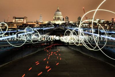 Light paintings on bridge against illuminated st paul cathedral at night