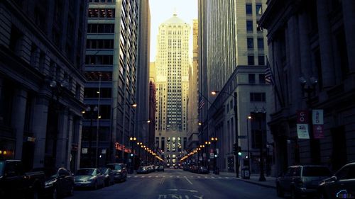 Cars on road amidst buildings in city