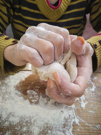 Close-up of hand holding bread on table