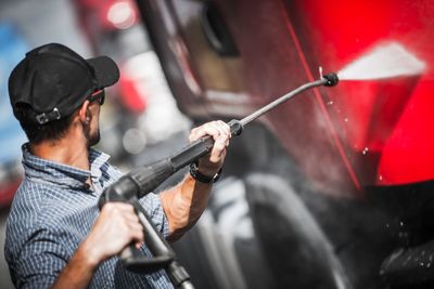 Close-up of man washing truck in garage