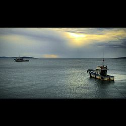 Boats in sea at sunset