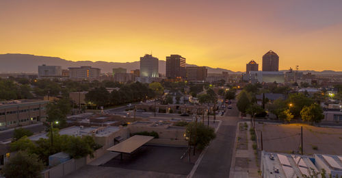 High angle view of trees and buildings against sky during sunset