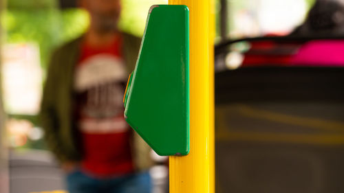 Close-up of yellow toy car on pole in city