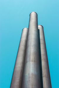 Low angle view of smoke stack against blue sky