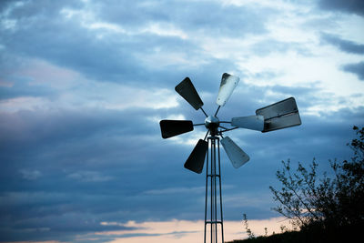 Low angle view of windmill against sky at sunset