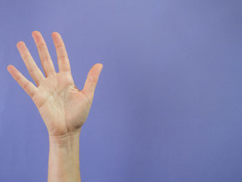 Close-up of hand against blue background