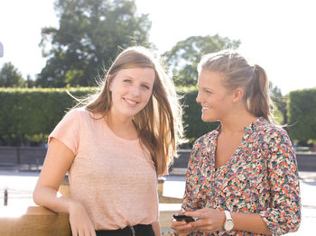 Smiling young women holding cell phone