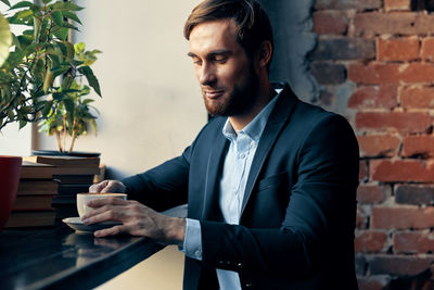 Man looking at camera against wall