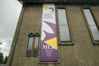 Low angle view of road sign against building