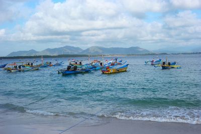 Boats moored on sea against sky