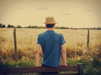 Rear view of boy standing on grassy field