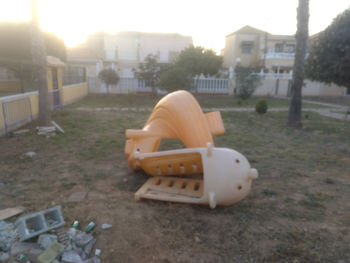 Abandoned chair against buildings in city