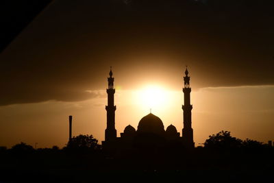 Low angle view of silhouette building against sky during sunset