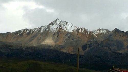 Scenic view of mountains against cloudy sky