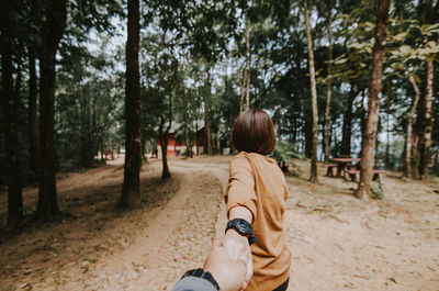 Cropped image of boyfriend holding girlfriend hand at beach