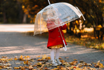 Woman holding wet umbrella during autumn