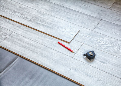 High angle view of pencil with tape measure on wooden table
