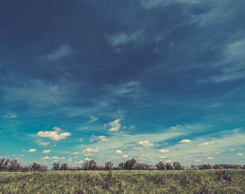 Scenic view of field against cloudy sky