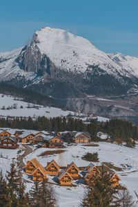 A picturesque vertical shot of the snowcapped french alps mountains and the ski resort buildings