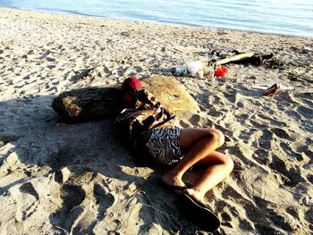 High angle view of woman relaxing on sand at beach