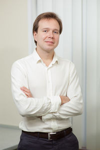 Portrait of confident businessman with arms crossed standing at office