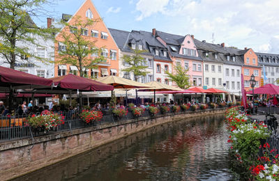 Canal amidst buildings in city against sky