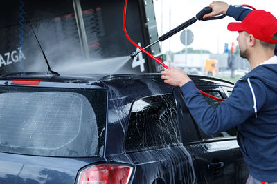 Midsection of man washing car