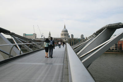 People on london millennium footbridge leading towards st paul cathedral