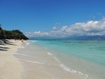 Scenic view of beach against blue sky