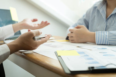 Midsection of business colleagues working on table