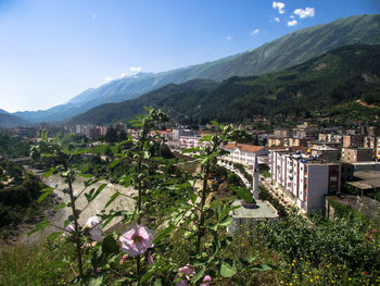 Scenic view of residential district and mountains against sky