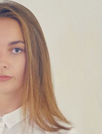 Portrait of young woman against white background