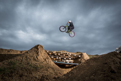 Low angle view of man jumping while doing bmx cycling