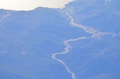 Aerial view of land and mountains against sky